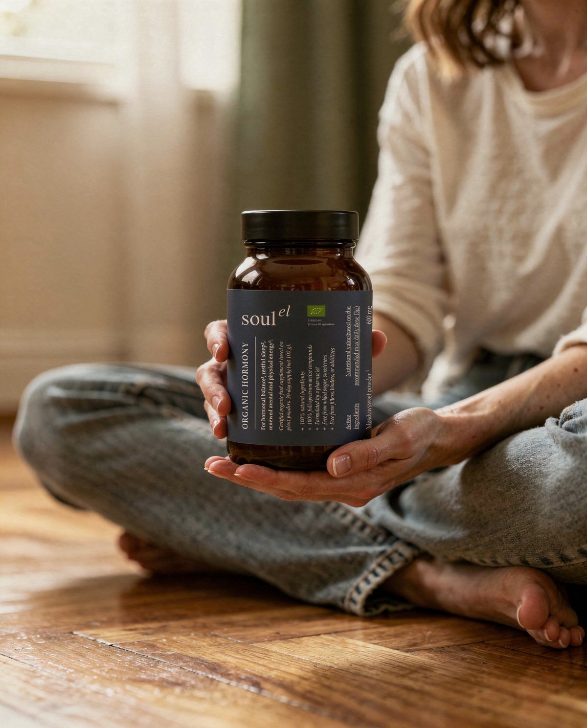 Person sitting at home holding a Soulel Organic Hormony bottle