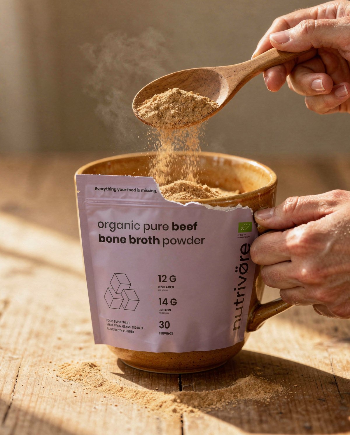 Scooping Nutriø̈tēca Bone Broth powder into a warm mug